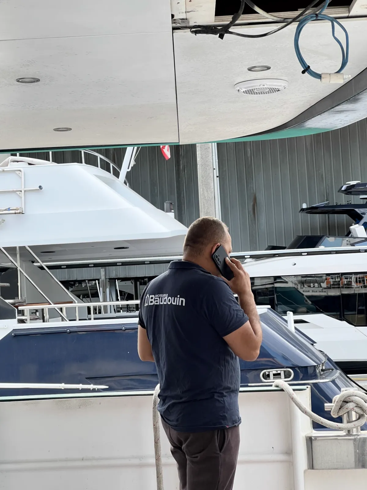 Técnico de HTC Mechanic con el polo de Moteurs Baudouin junto a un yate en Miami